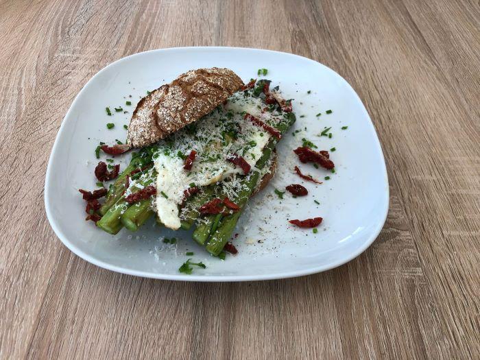 Spiegelei auf grünem Spargel und Brot